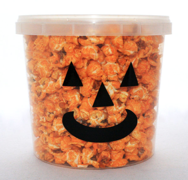 A jack'o'lantern tub filled with cheddar popcorn.